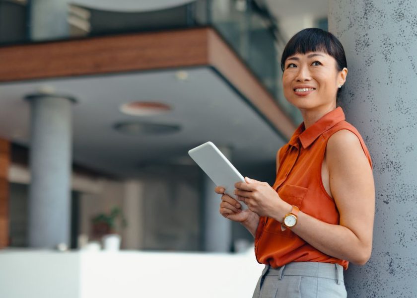 Smiling Japanese Professional Woman Using Tablet in Modern Office Setting
