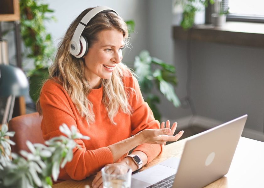 mature adult woman with laptop and headphones ( video call)